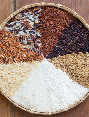 Round shallow basket tray , top with different varieties of rice. White rice, Brown rice, Red rice, black rice and mix varietes of rice.