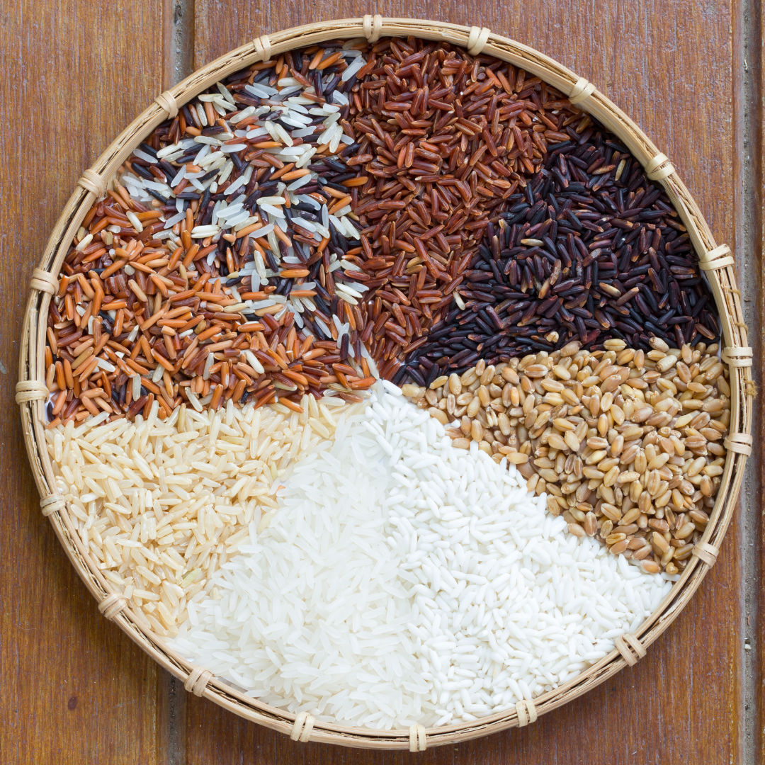 Round shallow basket tray , top with different varieties of rice. White rice, Brown rice, Red rice, black rice and mix varietes of rice.