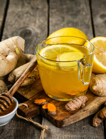 Glass with tea surrounded by Ginger,Turmeric,lemon and honey