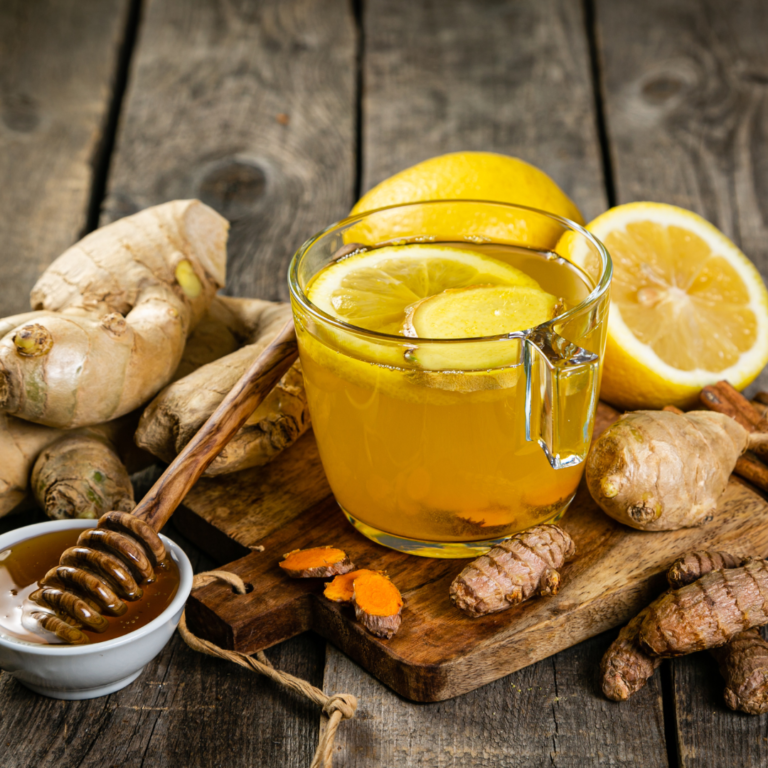 Glass with tea surrounded by Ginger,Turmeric,lemon and honey