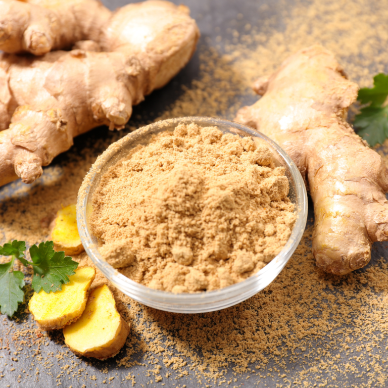 Whole rhizome ginger in the right and back with sliced ginger in left in the middle the bowl is full of powdered ginger